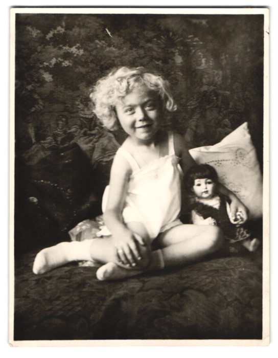 Photograph Marianne with her doll, doll, dolly sitting on sofa