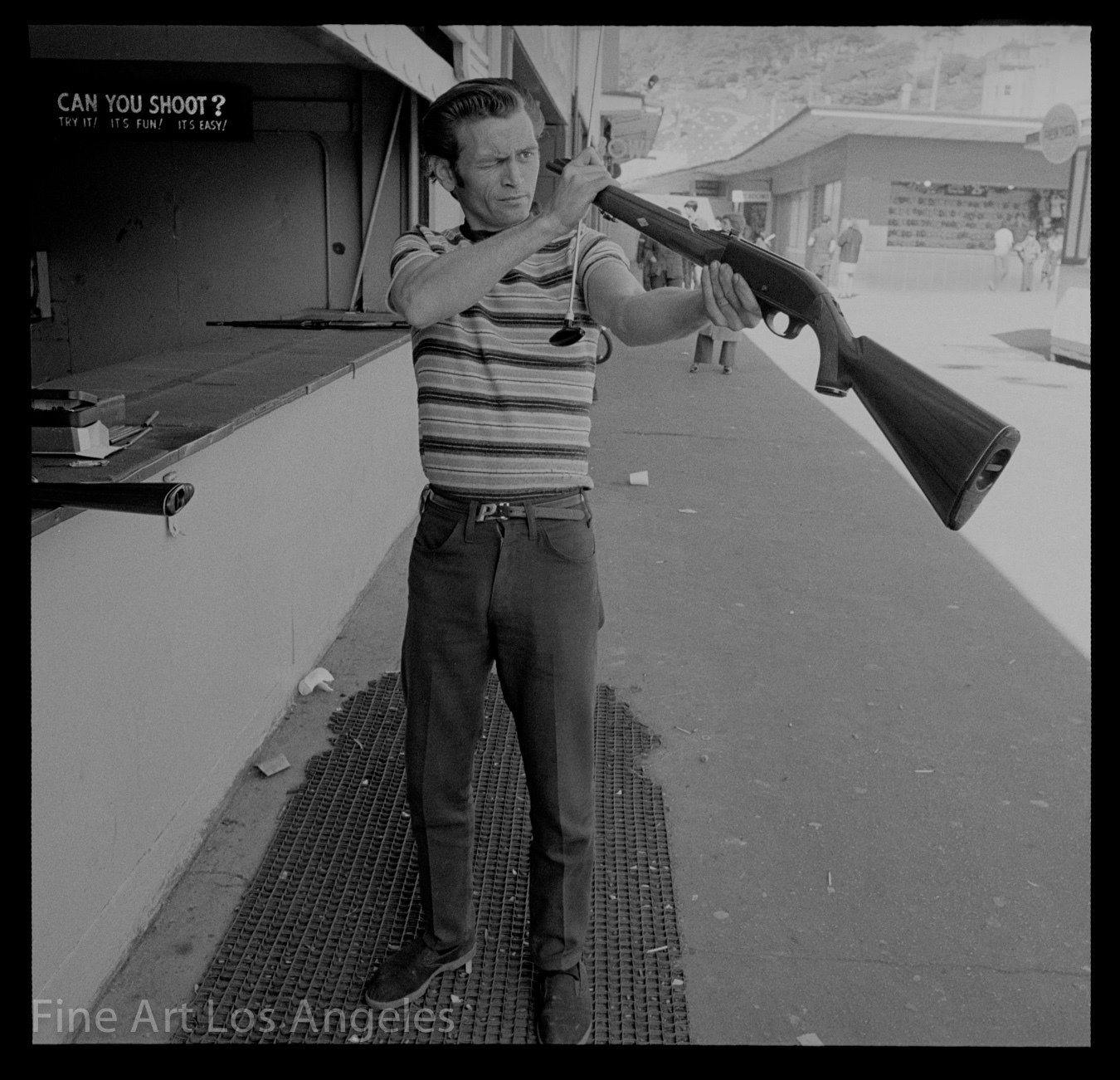 Neal White Photo, Man Eyes Gun at Shooting Range, sideshow, 1970s