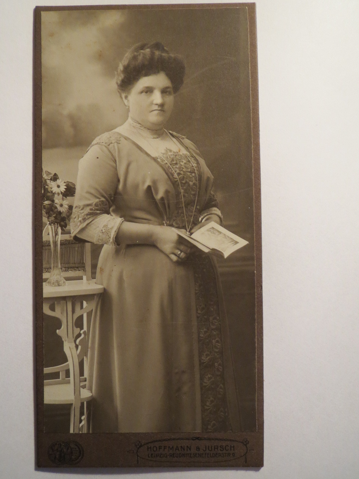 Leipzig-Reudnitz-standing woman in dress with book-portrait/cab